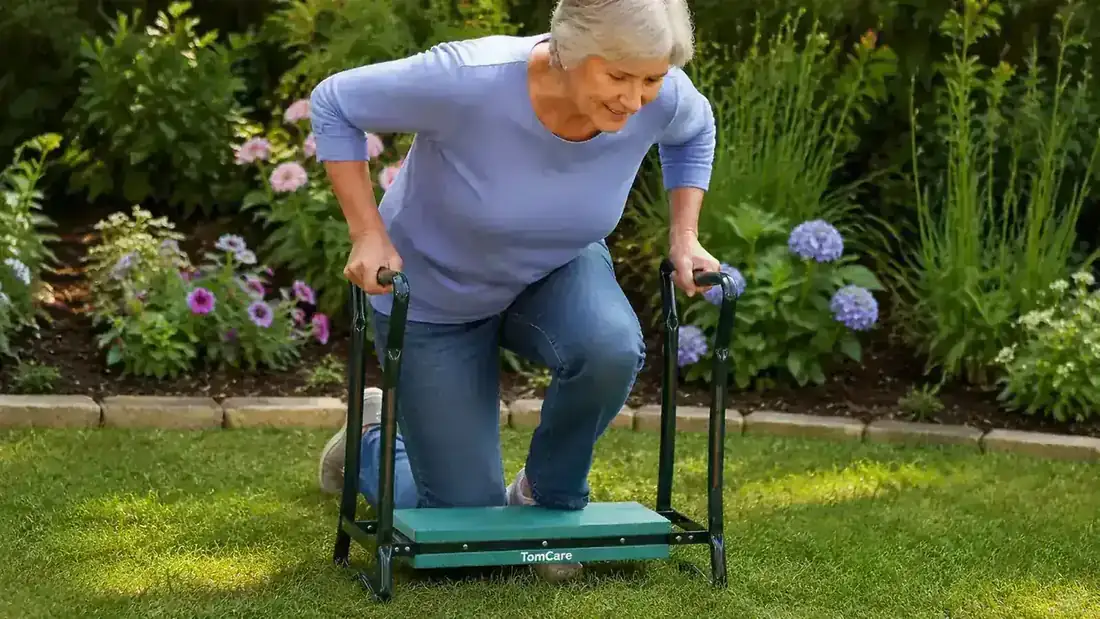 Close-up of a gardener pressing down on the support handles of a TomCare kneeler to rise from the ground